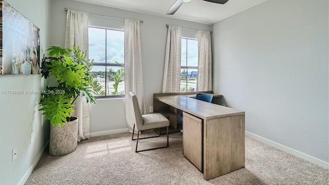 carpeted home office featuring baseboards and a ceiling fan