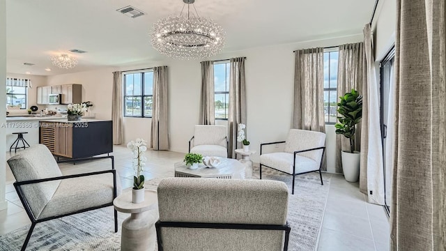 living area with an inviting chandelier, light tile patterned flooring, and visible vents
