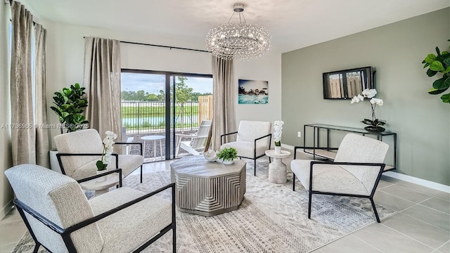 living area featuring a water view, a notable chandelier, baseboards, and light tile patterned floors