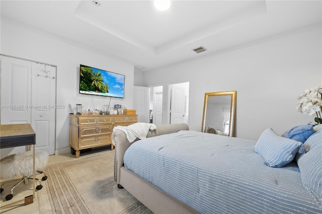 bedroom with a raised ceiling and visible vents