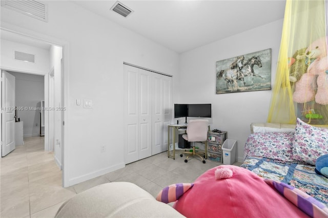 tiled bedroom featuring baseboards, a closet, and visible vents