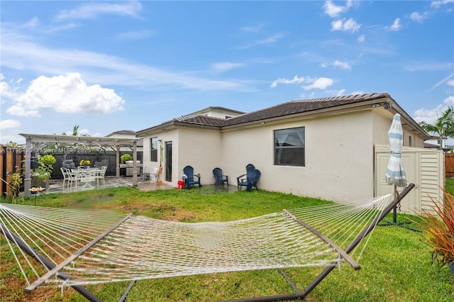 rear view of house with a yard, a patio, stucco siding, a fenced backyard, and a pergola
