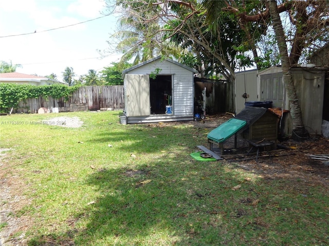 view of yard featuring an outbuilding, a fenced backyard, and a storage unit