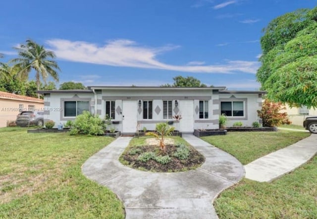 view of front of property with stucco siding and a front lawn