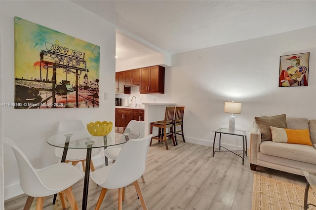 dining room with baseboards and light wood finished floors