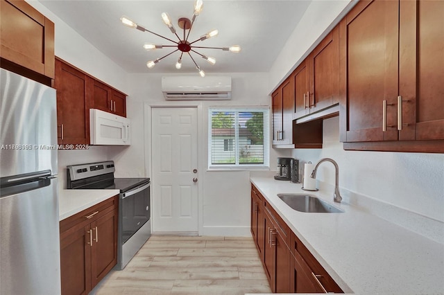 kitchen featuring a sink, stainless steel appliances, an inviting chandelier, light wood finished floors, and a wall unit AC
