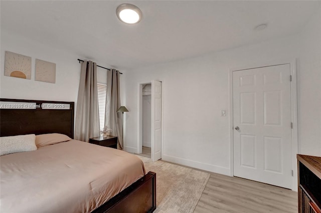 bedroom with light wood-style flooring and baseboards