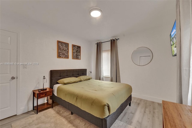bedroom featuring light wood-style flooring and baseboards