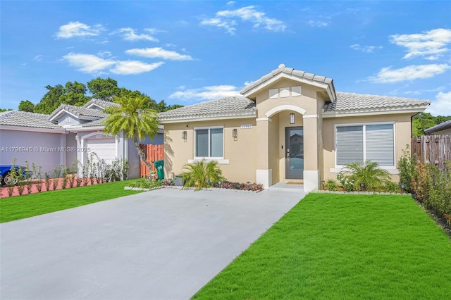 view of front of property featuring a front lawn, stucco siding, a tile roof, and fence