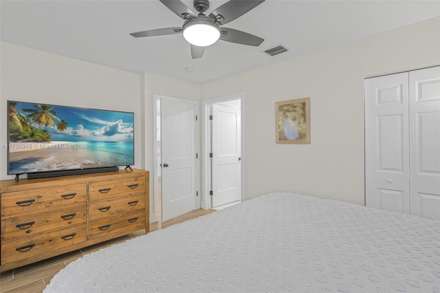 bedroom featuring a closet, visible vents, light wood-style flooring, and a ceiling fan