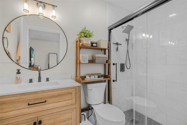 bathroom with a stall shower, vanity, and toilet