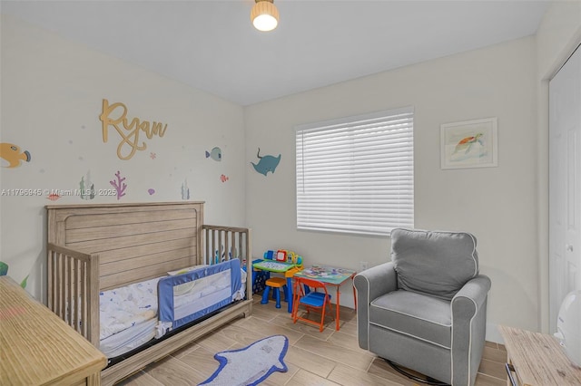 bedroom with wood finish floors and a nursery area