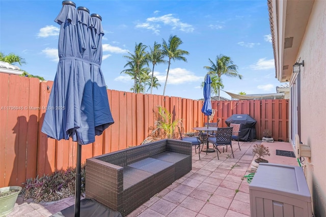 view of patio / terrace with a fenced backyard, area for grilling, and outdoor dining area