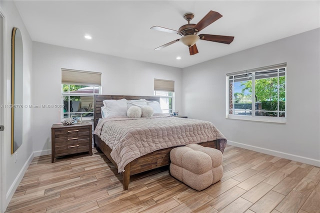 bedroom featuring light wood finished floors, baseboards, and multiple windows