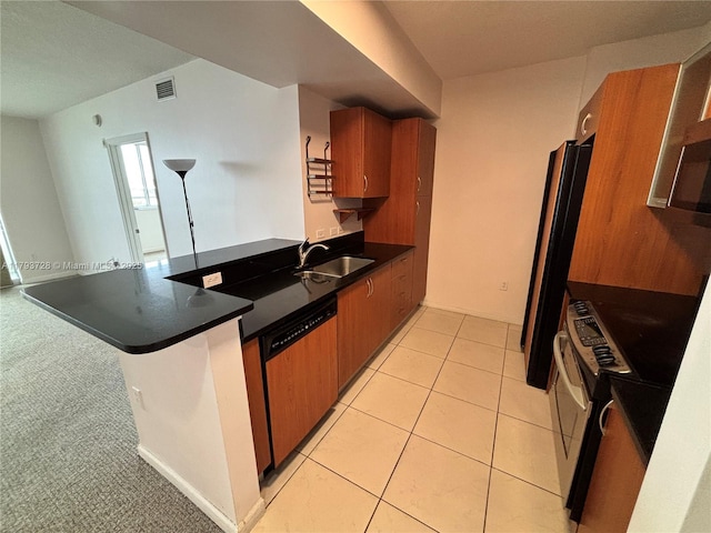 kitchen featuring visible vents, a sink, dishwashing machine, a peninsula, and brown cabinets
