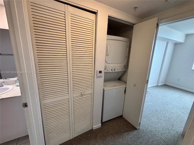 laundry area featuring a sink, stacked washing maching and dryer, laundry area, and carpet floors