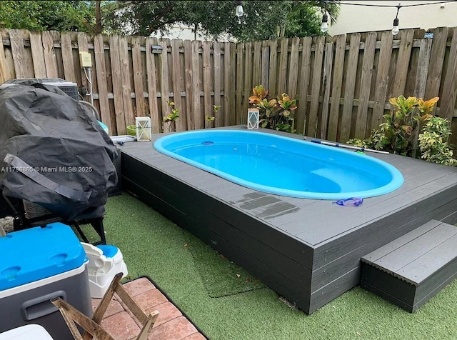 view of pool featuring a hot tub and fence