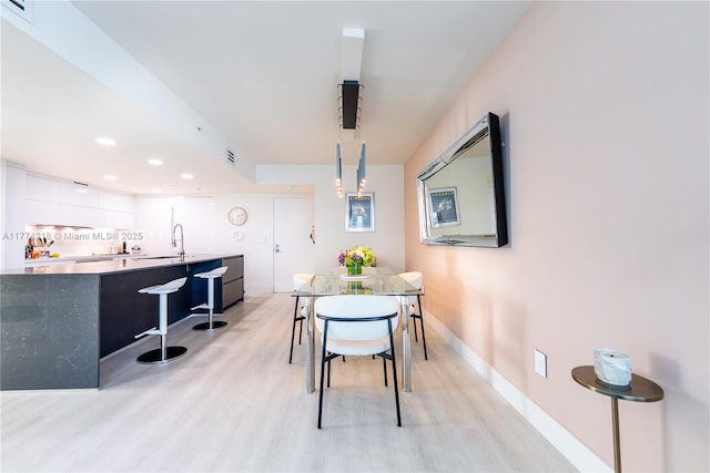 dining space featuring light wood finished floors, visible vents, baseboards, and recessed lighting