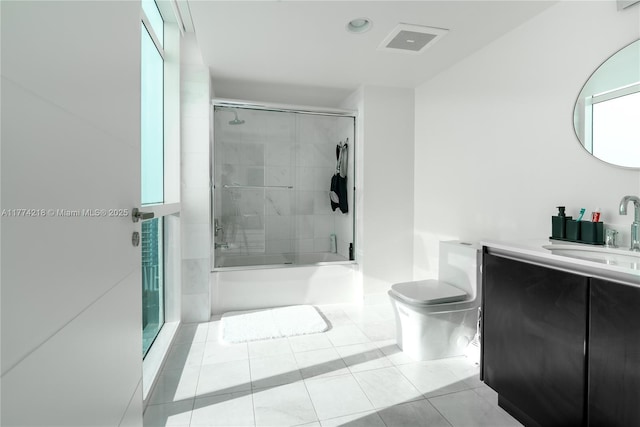 bathroom featuring toilet, visible vents, tile patterned flooring, bath / shower combo with glass door, and vanity