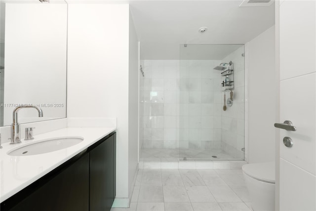 bathroom with vanity, toilet, and tiled shower