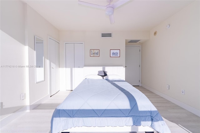 bedroom featuring a ceiling fan, baseboards, visible vents, and light wood-type flooring