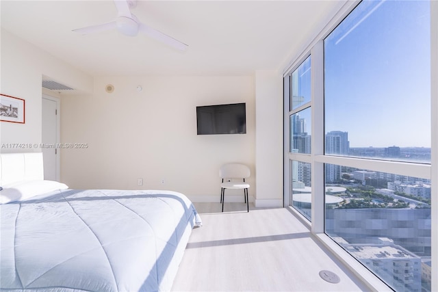 bedroom featuring wood finished floors, baseboards, and ceiling fan
