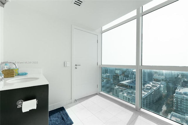 bathroom featuring a wall of windows, visible vents, and vanity