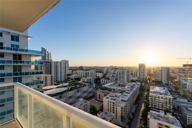 balcony at dusk featuring a view of city