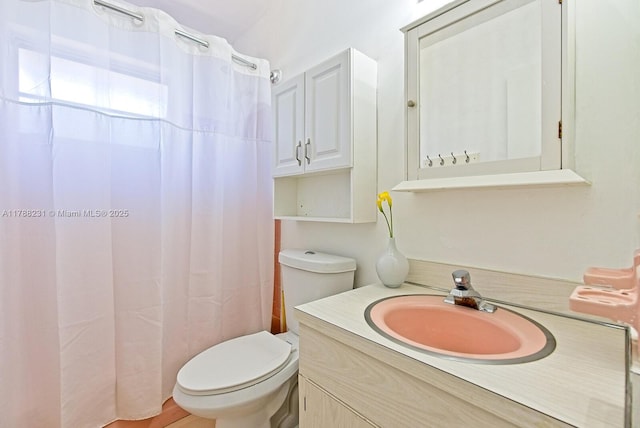 bathroom featuring toilet, a shower with shower curtain, and vanity