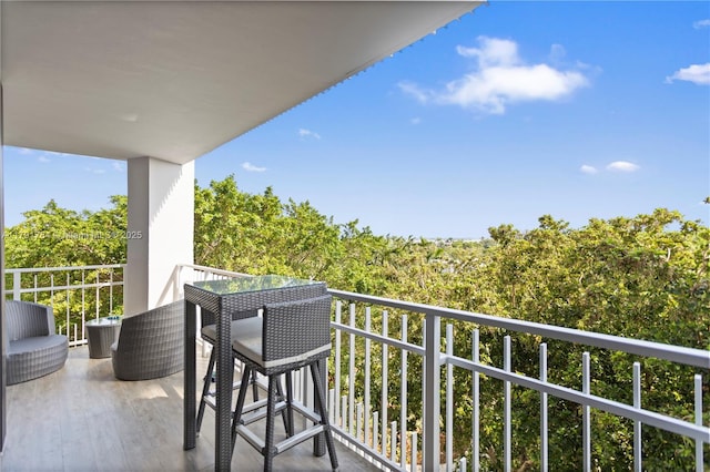balcony featuring a wooded view
