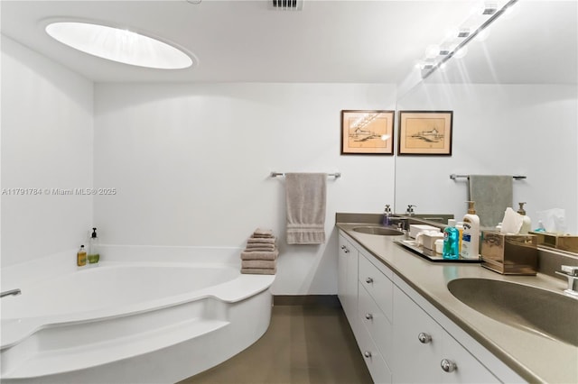 full bath featuring baseboards, a bath, double vanity, and a sink