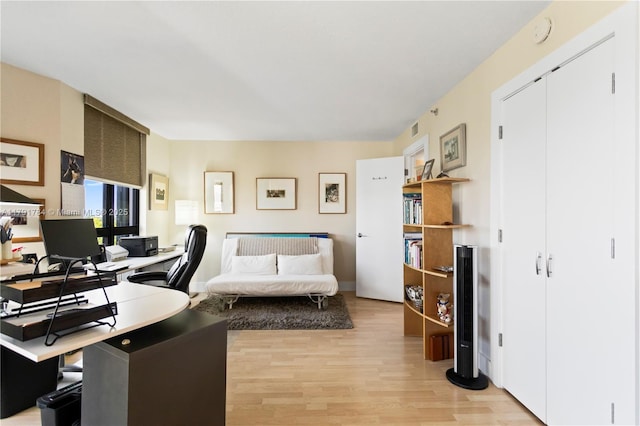office space featuring baseboards, visible vents, and light wood-style floors