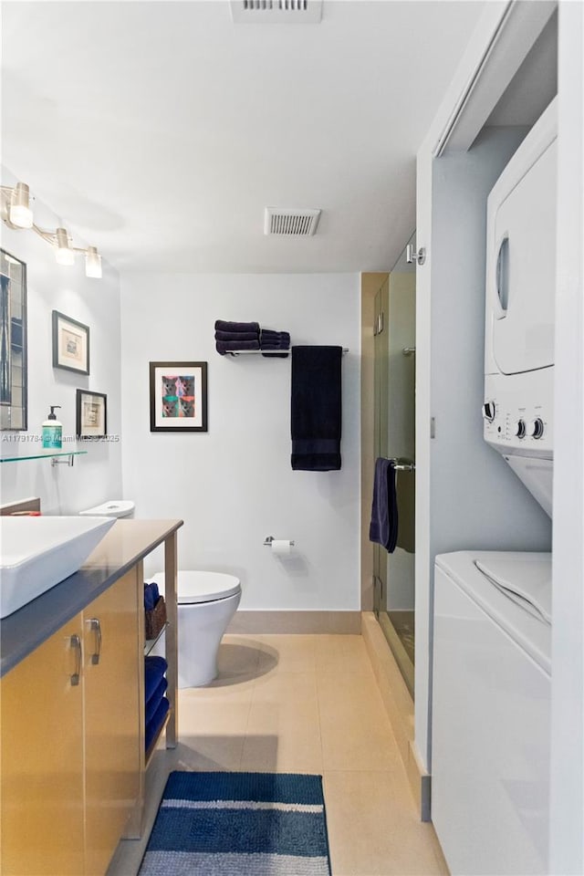 full bathroom with toilet, stacked washer / drying machine, a shower stall, and visible vents