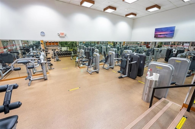 gym featuring a high ceiling and a paneled ceiling