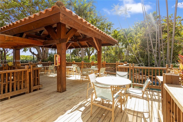 wooden deck with outdoor dining area and a gazebo