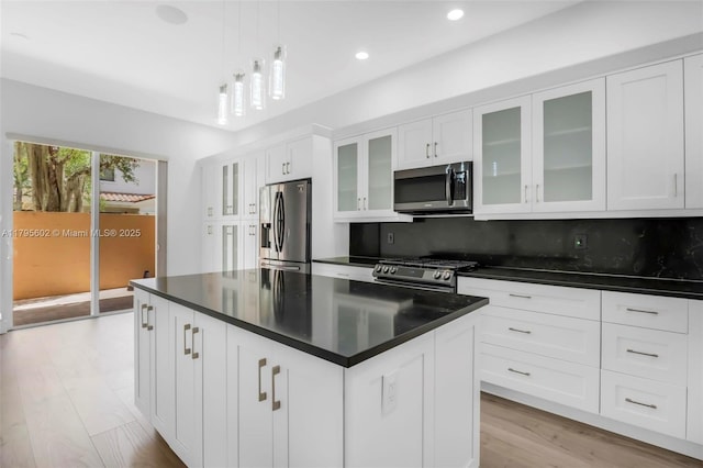 3040 NW 126th Ave, Sunrise, FL 33323 - kitchen featuring appliances with stainless steel finishes, dark countertops, white cabinets, a center island, and light wood-type flooring