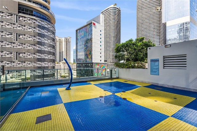 view of sport court with fence and a view of city