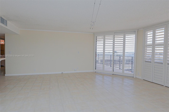1865 Brickell Ave Unit A514, Miami, FL 33129 - empty room with a textured ceiling, a wall of windows, baseboards, ornamental molding, and tile patterned flooring
