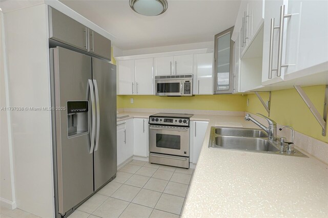 1865 Brickell Ave Unit A514, Miami, FL 33129 - kitchen featuring appliances with stainless steel finishes, a sink, light countertops, and white cabinets