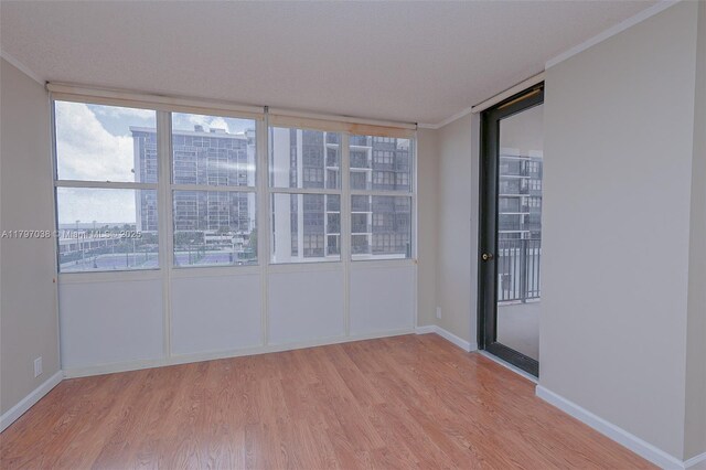1865 Brickell Ave Unit A514, Miami, FL 33129 - empty room with light wood-style floors, baseboards, ornamental molding, and a view of city