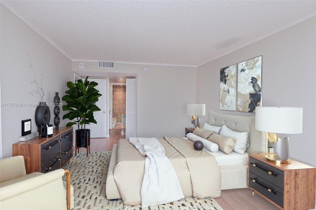 1865 Brickell Ave Unit A514, Miami, FL 33129 - bedroom featuring light wood-type flooring, crown molding, and a textured ceiling