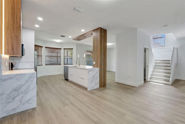kitchen with baseboards, modern cabinets, stainless steel appliances, and light wood-style flooring