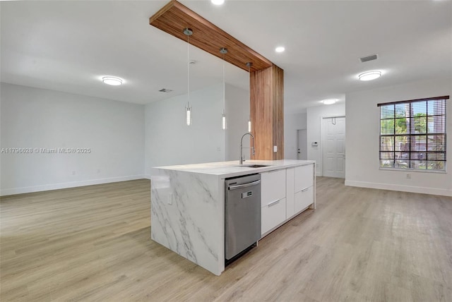 kitchen featuring stainless steel dishwasher, baseboards, a sink, open floor plan, and light wood-style floors