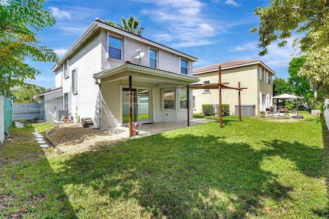 back of house featuring a yard, stucco siding, fence, and a patio