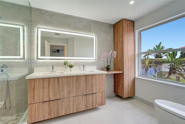 full bath with double vanity, toilet, marble finish floor, and a sink