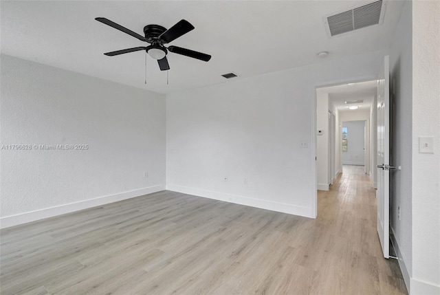empty room with light wood-type flooring, ceiling fan, baseboards, and visible vents