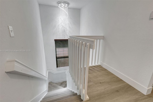 stairs with wood finished floors and baseboards
