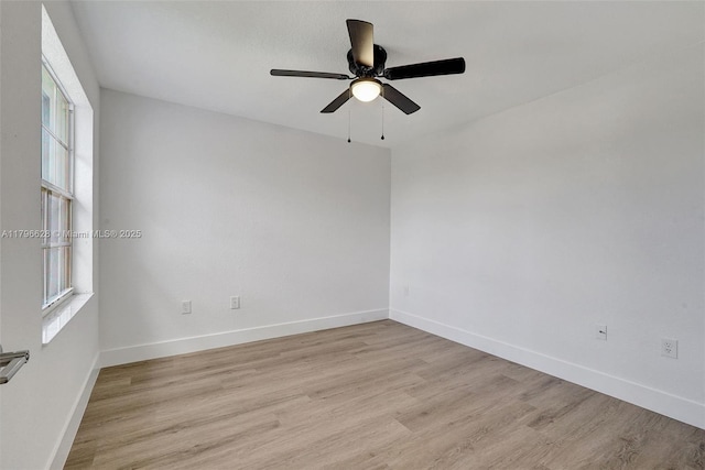 spare room with light wood-type flooring, baseboards, and ceiling fan