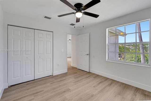 unfurnished bedroom featuring light wood-type flooring, visible vents, and multiple windows