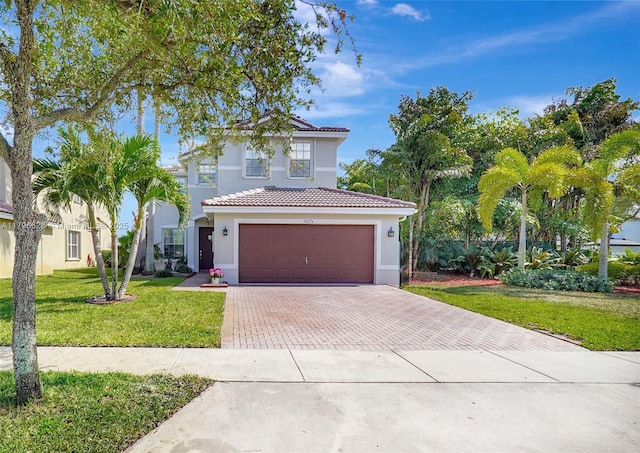 mediterranean / spanish-style house with a tiled roof, decorative driveway, a garage, stucco siding, and a front yard